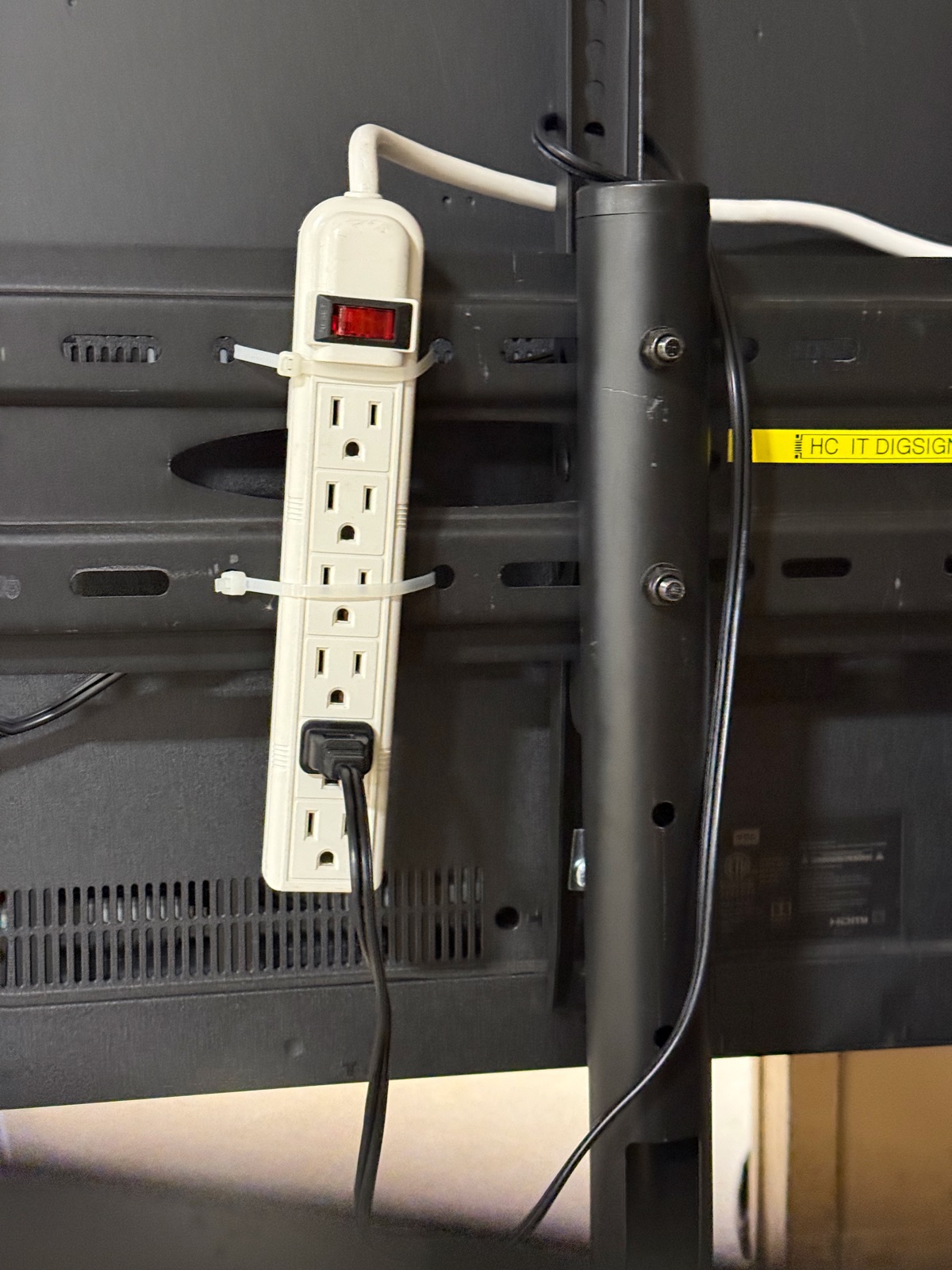 Power strip zip-tied to stand